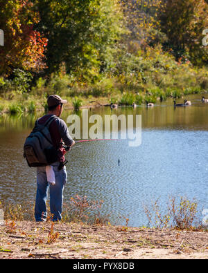 Fairfax, VA, USA--Octobre 30, 2018. Un homme est la pêche des rives du Lac Royal à Fairfax VA sur un après-midi d'automne. Banque D'Images