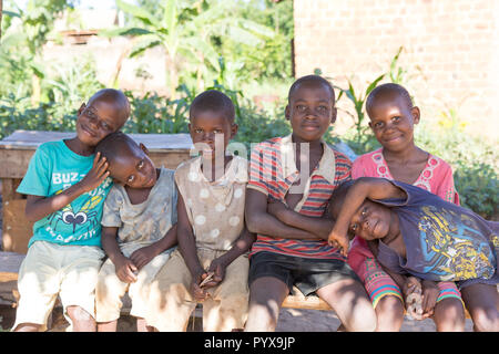 Un groupe d'enfants assis sur un banc. Ils sont sourire, rire et, semble-t-il, s'amusant, Banque D'Images