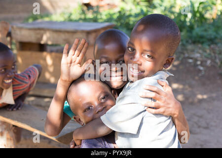 Un groupe d'enfants assis sur un banc. Ils sont sourire, rire et, semble-t-il, s'amusant, Banque D'Images