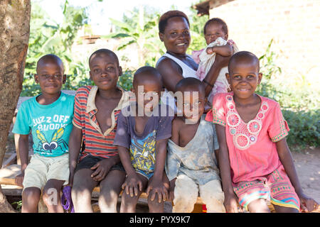 Un groupe d'enfants assis sur un banc. Ils sont sourire, rire et, semble-t-il, s'amusant, Banque D'Images