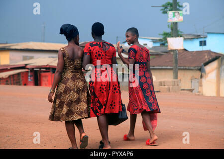 Trois femmes Ashanti marcher ensemble à la suite d'une célébration de la vie (funérailles) d'un éminent townsperson, Ghana Banque D'Images