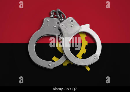 Drapeau de l'Angola et la police menottes. La notion de respect de la loi dans le pays et à la protection contre la criminalité. Banque D'Images