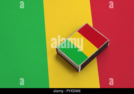 Mali drapeau est représenté sur une boîte d'allumettes qui se trouve sur un grand drapeau. Banque D'Images