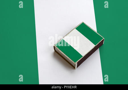 Nigéria drapeau est représenté sur une boîte d'allumettes qui se trouve sur un grand drapeau. Banque D'Images