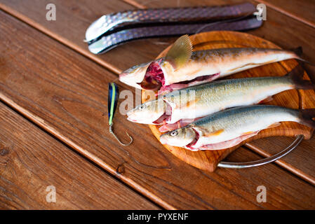 Les prises de poissons frais de la mer se trouve sur une planche à découper sur une table en bois. Top View copy space Banque D'Images