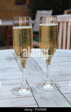 Deux flûtes de champagne assis sur table de pique-nique en bois Banque D'Images