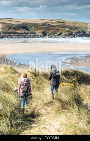 Les randonneurs sur un sentier dans les dunes avec vue sur plage de Crantock en Newquay en Cornouailles. Banque D'Images