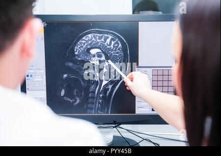 Les médecins estiment et discuter de l'image par résonance magnétique (IRM) du cerveau. Vue de dos, selective focus Banque D'Images