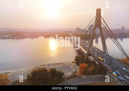 Pont de Moscou à Kiev au coucher du soleil en soirée . Paysage urbain de la capitale de l'Ukraine. La circulation sur route. Vue aérienne drone Banque D'Images