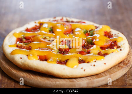 Une mini pizza sur une table en bois brun. Ces petites tourtes individuelles ou personnelles appelé aussi des pizzas. Banque D'Images