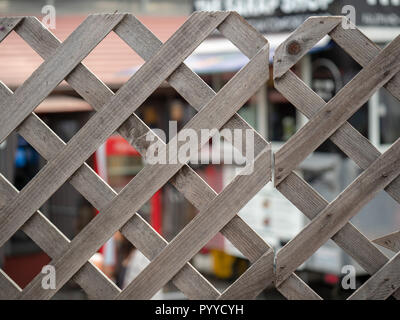 Clôture en forme de diamant en bois debout en face d'un centre commercial et coin repas Banque D'Images
