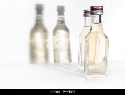 Deux bouteilles d'alcool vintage avec des ombres sur le mur. Banque D'Images