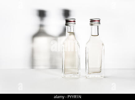 Deux bouteilles d'alcool vintage avec des ombres sur le mur. Banque D'Images