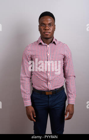 Young African businessman standing against white background Banque D'Images