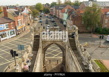 Sunny high view de gens assis à des tables de café sur le dessus de la ville historique de Walmgate Bar, la jonction de route, de la circulation et des boutiques - York, North Yorkshire, Angleterre, Royaume-Uni. Banque D'Images