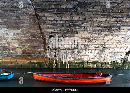 Une image capturée en fin d'après-midi d'un petit bateau amarré sous les arches de Richmond Bridge à Londres, Angleterre Banque D'Images