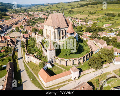 La ville et l'église fortifiée de Biertan en Transylvanie, Roumanie. Château médiéval sur une colline, tours élevées, murs, toits de tuiles rouges, entourée d'un village. Banque D'Images