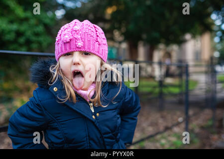 Naughty Cute Caucasian girl wearing pink hat coller sa langue out Banque D'Images