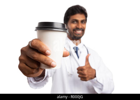 Close-up tasse de café à emporter tenue par friendly indian medic avec le pouce jusqu'en approuver le geste isolé sur fond blanc Banque D'Images
