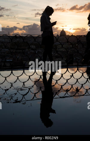 Roma, Italie. 30Th Oct, 2018. Fille au coucher du soleil avec la réflexion sur flaque Coucher du soleil vu de la terrasse de l'Pincio et depuis le belvédère en face de la Casina Valadier à Rome Crédit : Matteo Nardone/Pacific Press/Alamy Live News Banque D'Images