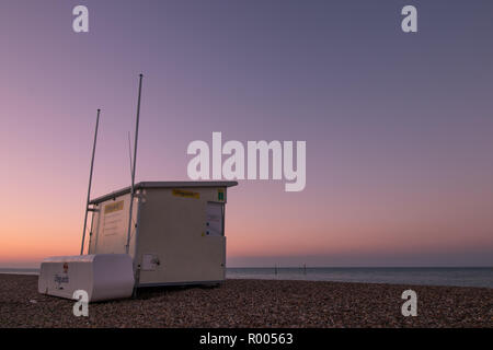 Lifeguard station à lever du soleil sur une plage de galets Banque D'Images