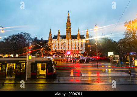 Vienne, Autriche. L'hôtel de ville illuminée à Noël avec patinoire, décorations. La circulation automobile dans le centre-ville, tramway à Vienne Banque D'Images