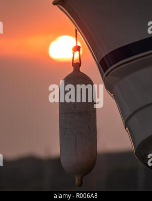 Une aile de bateaux à voile close up avec le soleil couchant en arrière-plan Banque D'Images