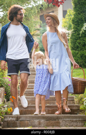 Jeune famille avec panier pique-nique après descendant des escaliers à l'extérieur de Green Park Banque D'Images