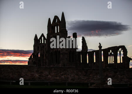 Whitby, Yorkshire, UK : 25 octobre 2018. Lever du Soleil contre les ruines de l'abbaye de Whitby comme la ville Banque D'Images