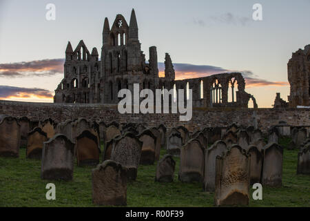 Whitby, Yorkshire, UK : 25 octobre 2018. Lever du Soleil contre les ruines de l'abbaye de Whitby comme la ville Banque D'Images