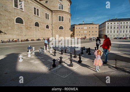 Salzbourg, Autriche, Salzburger Land - le 11 septembre 2018 : l'homme avec une petite fille jouant aux échecs sur Kapitelplatz énorme (Chapitre) sur l'état ensoleillé Banque D'Images