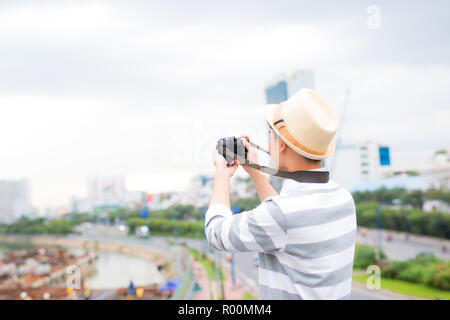 Beau jeune homme, un étudiant ou un photographe pigiste sourires et rires en huis clos Banque D'Images