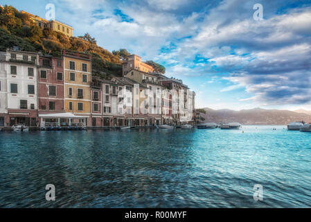 Soleil rose pittoresque vue sur Portofino, Italie avec des nuages sur un calme mer Ligurienne et maisons au bord de Banque D'Images