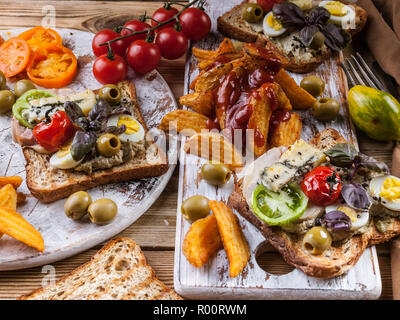 Délicieux toasts à l'avocat, oeufs de caille, tomates, fromage bleu Dor et de frites. La cuisine de l'auteur. Servant des plats originaux Banque D'Images