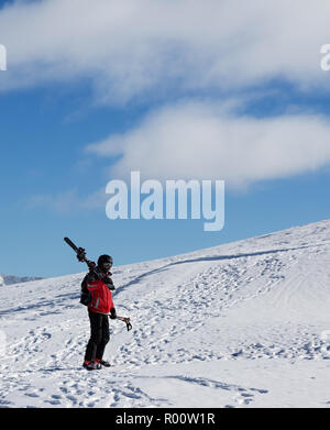 Avec skieur skis sur l'épaule aller jusqu'en haut de la montagne dans jolie journée ensoleillée. Montagnes du Caucase en hiver, la Géorgie, la région, le Mont Gudauri. Kudebi Banque D'Images