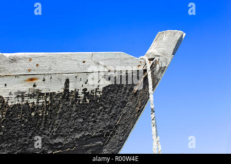 La proue de l'ancien bateau en bois avec une surface goudronnée contre le ciel bleu Banque D'Images