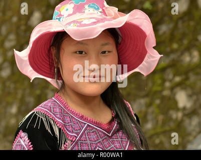 Les jeunes des minorités H'Mong vietnamienne hill-tribu femme porte un chapeau de soleil rose fantaisie et noir H'Mong traditionnelles des vêtements. Banque D'Images