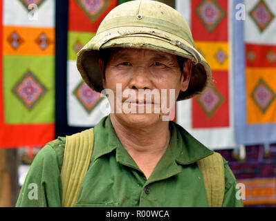 Personnes âgées Vietnamiens du Nord ancien soldat porte un vieux vert chemise militaire et un Nord Vietnam casque colonial de l'armée. Banque D'Images