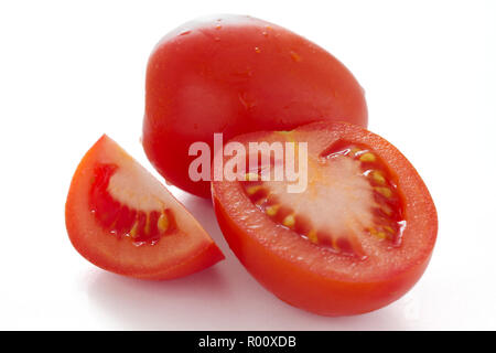 Tomate prune rouge coupé en deux sur la surface blanche Banque D'Images