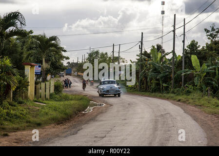 Une voiture américaine classique conduit le long d'une route à Viñales, Cuba. Banque D'Images