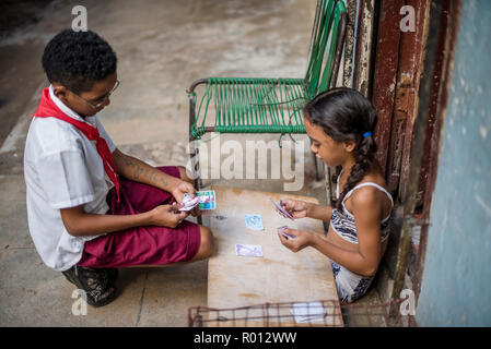 Deux enfants cubains jouer aux cartes dans un allié. Banque D'Images