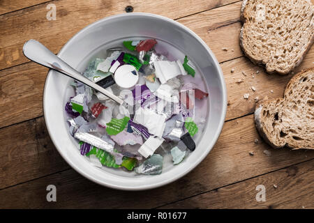 Un bol de soupe composée de déchets plastiques avec du pain. Banque D'Images