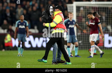 Un pitch invader portant un masque de scream est enlevé par un membre de la sécurité pendant la Coupe du buffle, quatrième tour à la London Stadium. Banque D'Images