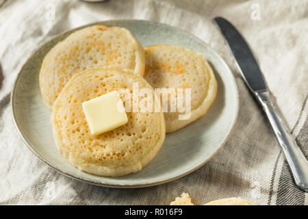 Des Crumpets britannique grillé avec du beurre pour le petit déjeuner Banque D'Images