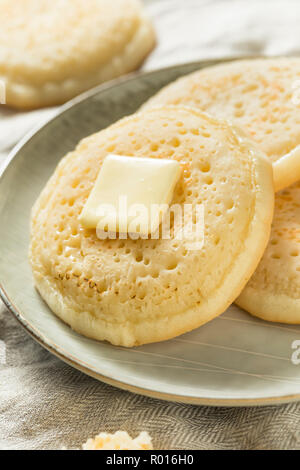 Des Crumpets britannique grillé avec du beurre pour le petit déjeuner Banque D'Images