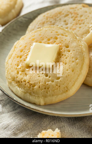 Des Crumpets britannique grillé avec du beurre pour le petit déjeuner Banque D'Images