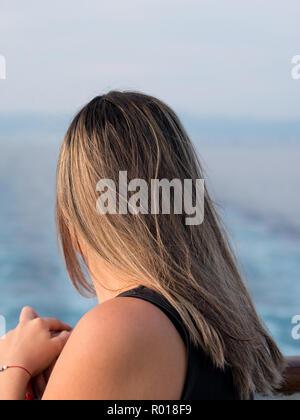 Young caucasian woman with long hair regardant la mer de l'arrière Banque D'Images