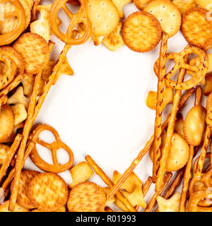 Une photo d'un assortiment de sel des craquelins, des bâtons, des bretzels, et poissons, tourné par le haut sur un fond blanc, ce qui en fait un cadre, avec un lieu de tex Banque D'Images