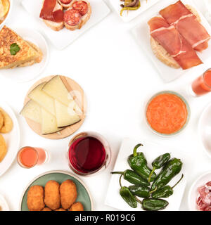 Une photo prise à la verticale d'une sélection de tapas espagnoles, tourné par le haut sur un fond blanc, formant une trame pour copier l'espace, avec un verre de vin rouge w Banque D'Images