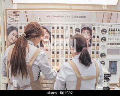 Octobre 2018 - Séoul, Corée du Sud : Deux jeunes femmes debout un avant d'un plateau avec des produits de maquillage de la marque de soin de la Corée du Sud, Innisfree Banque D'Images